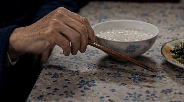 独食特写：父亲布满皱纹的手执筷，对着一碗饭